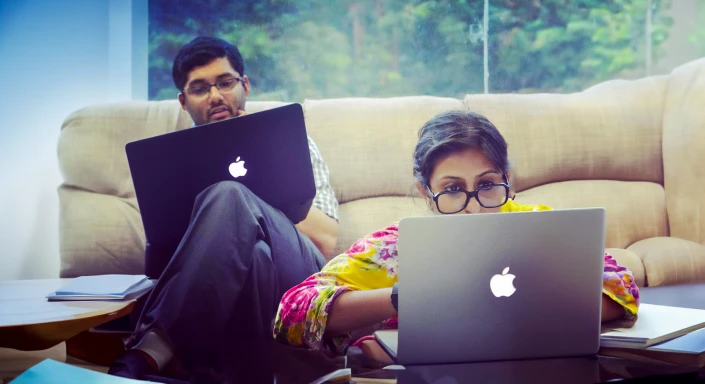 Clinikk co-founders working on laptops in a casual office setting.