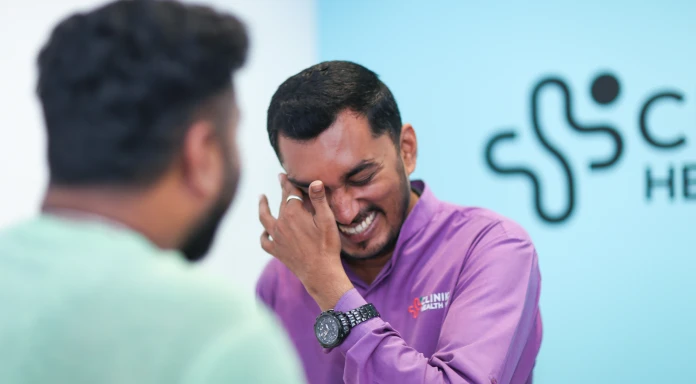 Clinic staff sharing a light moment with patient at Clinikk Health Hub.